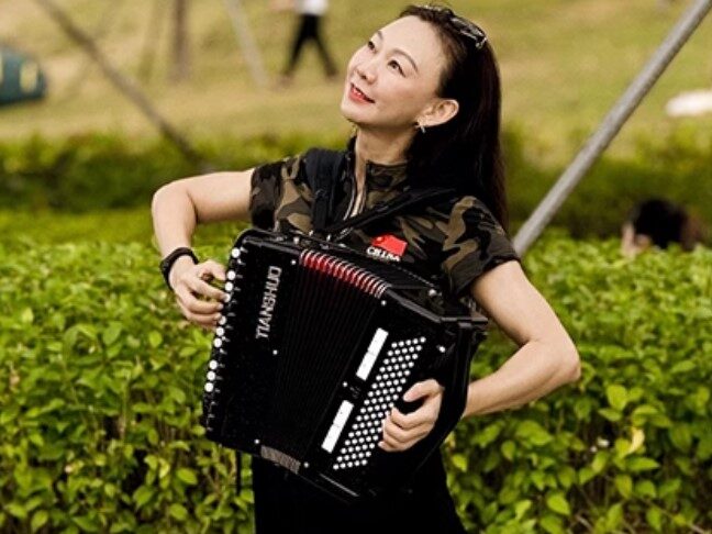 Lady playing Tianshuo accordion outdoor